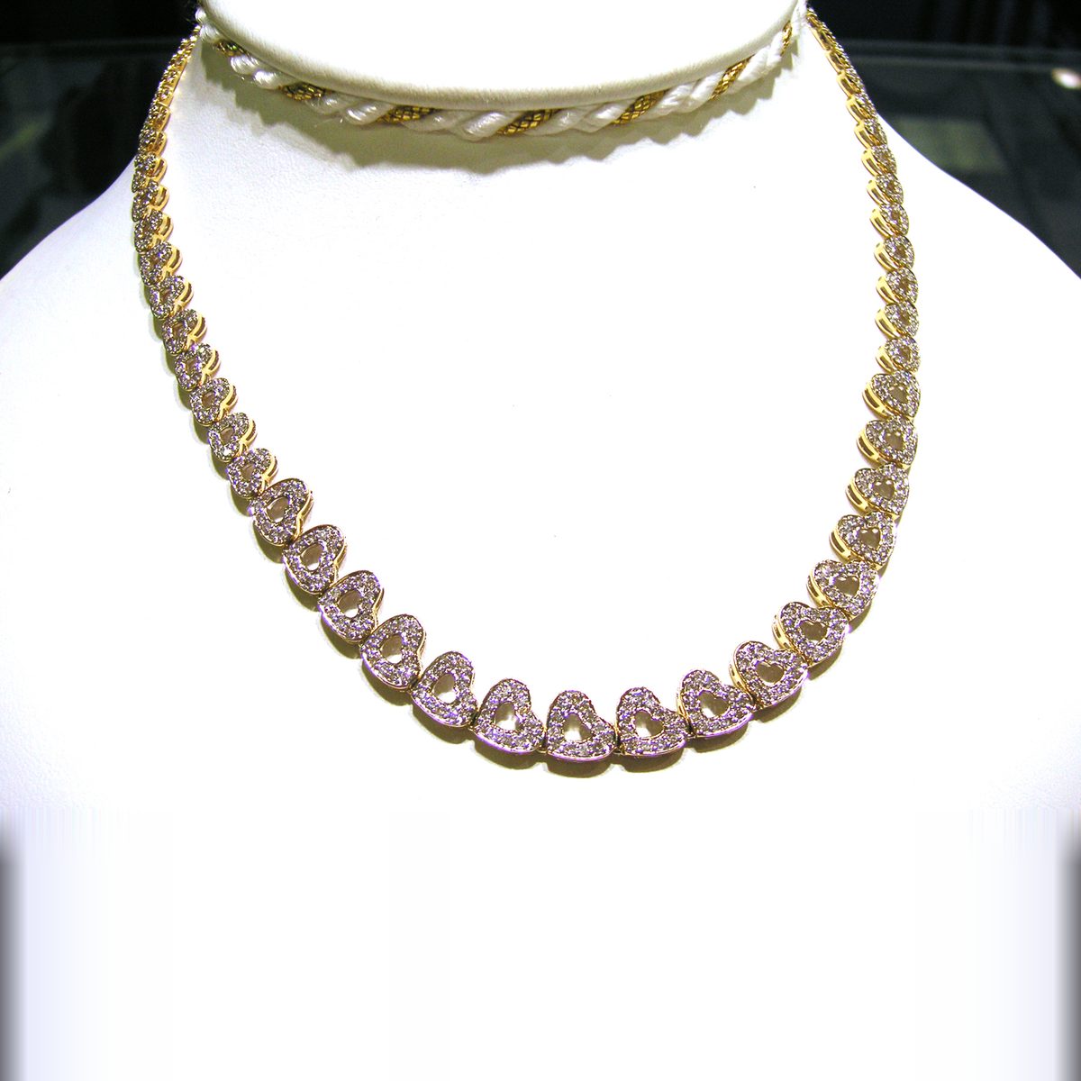 Yellow gold necklace lined with pave diamond heart links