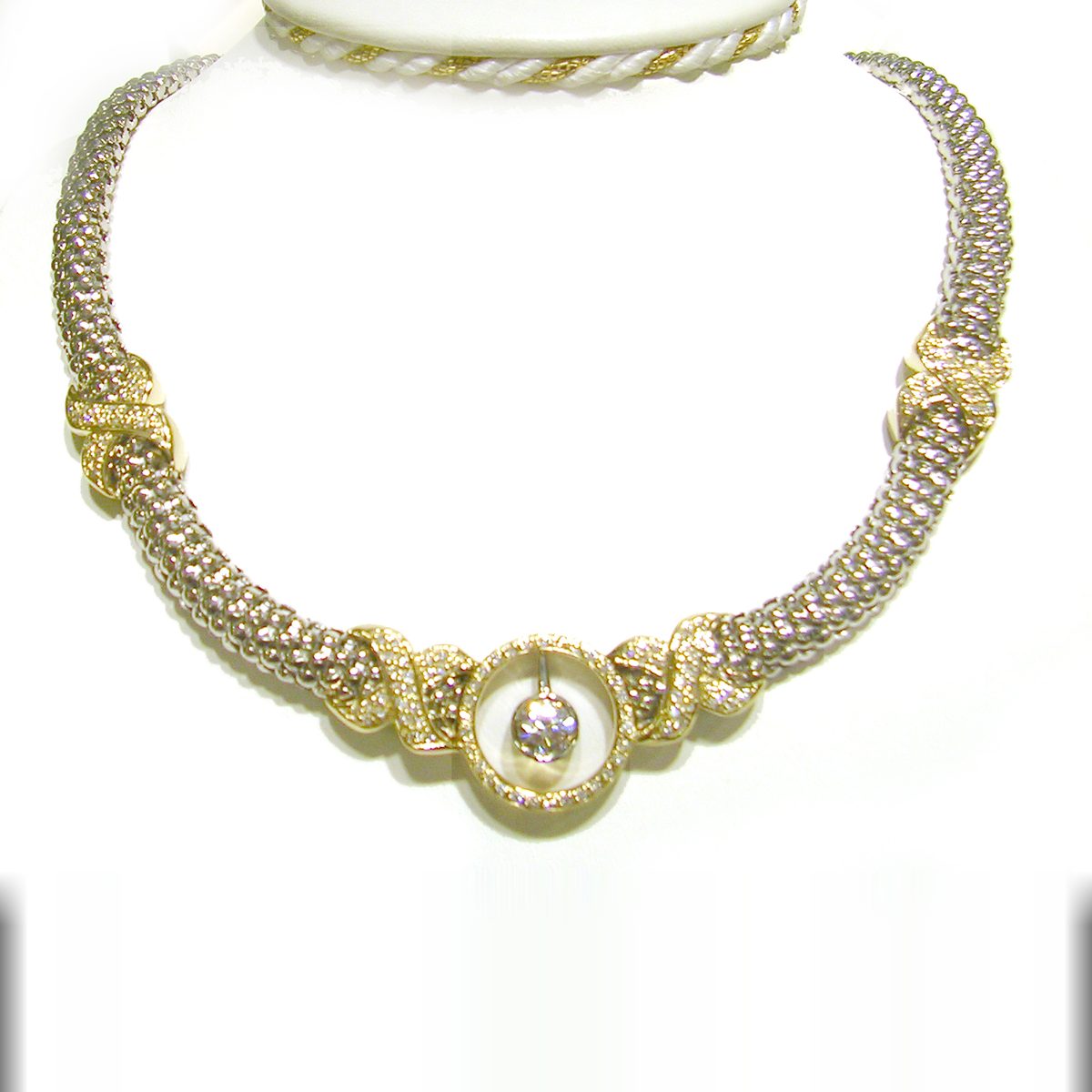 Two tone woven necklace with pave diamond accents and a round center diamond